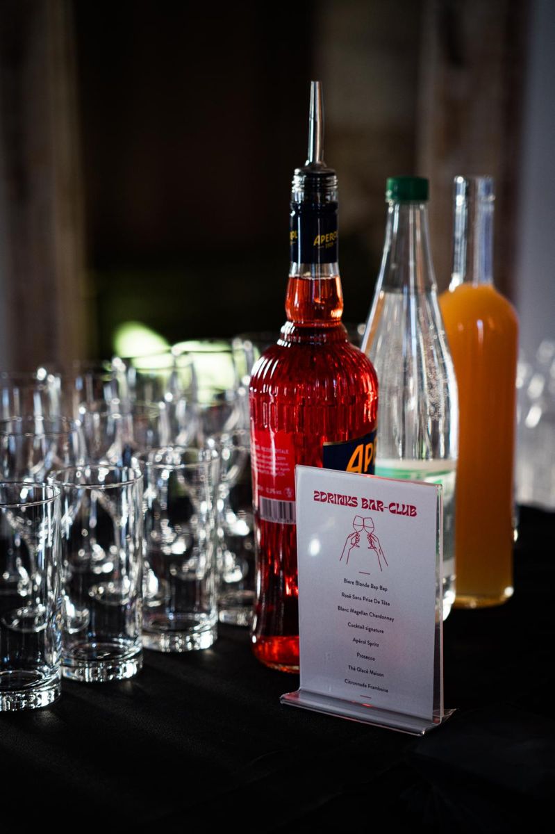 Le bar 2Drinks installé pour un événement, avec bouteilles, verres et carte des cocktails